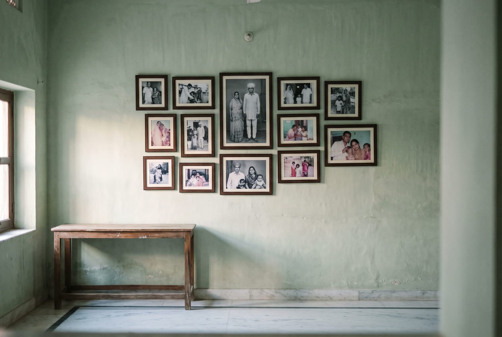 Framed family prints arranged on a pale wall